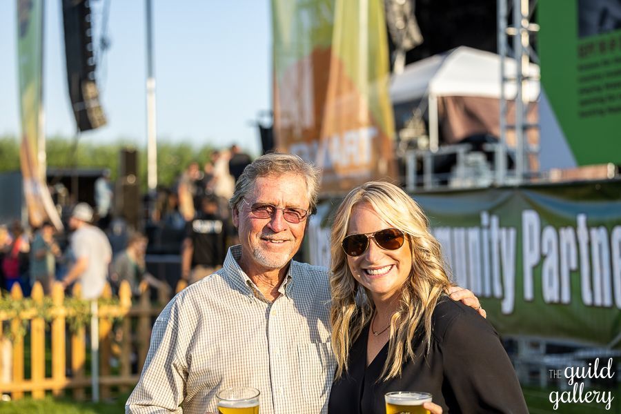A man and a woman are posing for a picture at a concert.
