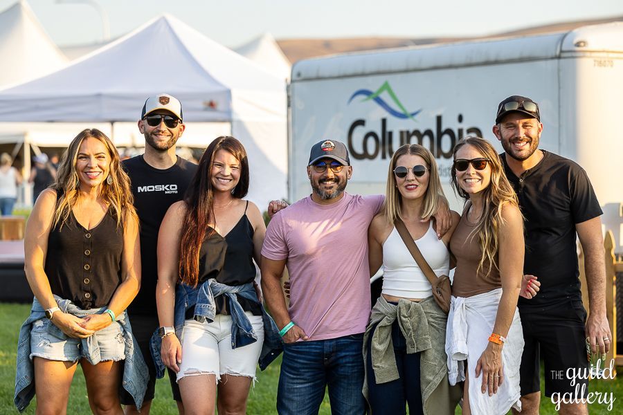 A group of people are posing for a picture in front of a columbia trailer.