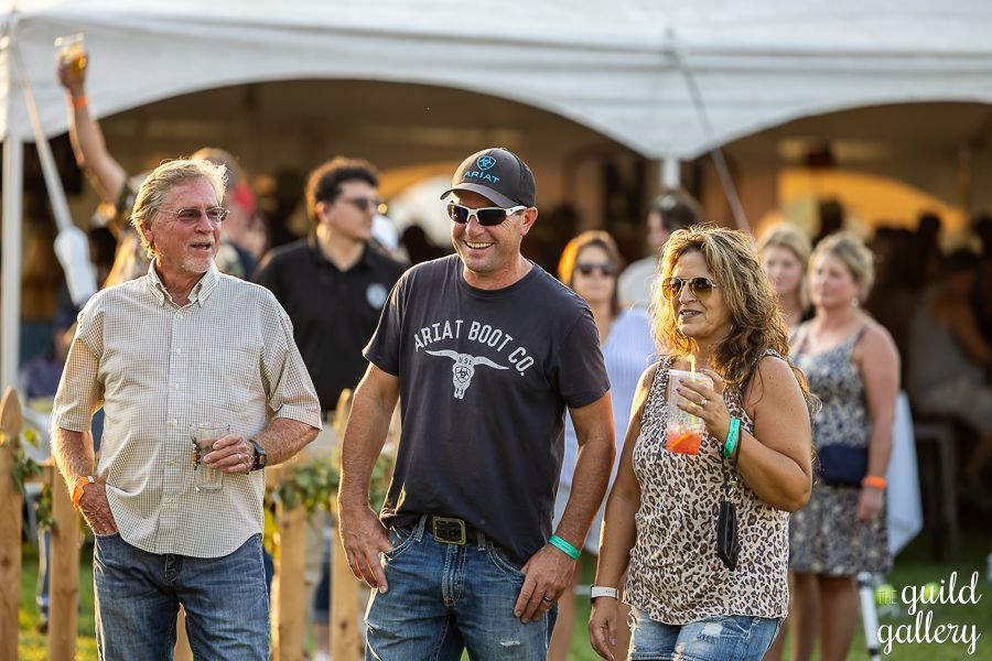A group of people are walking in a line under a tent.