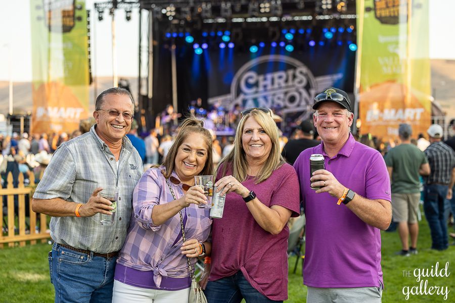 A group of people are posing for a picture at a concert.