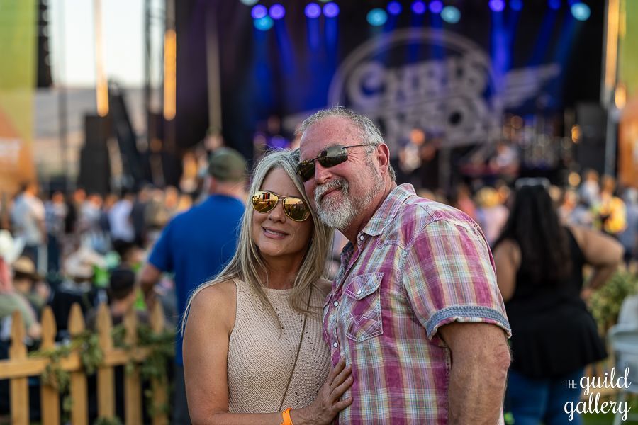 A man and a woman are posing for a picture at a concert.