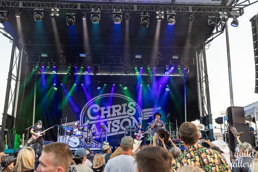 A group of people are standing in front of a stage at a concert.