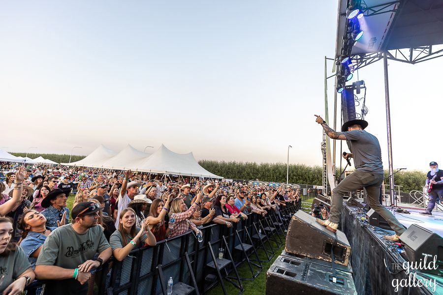 A man is standing on a stage in front of a crowd at a concert.