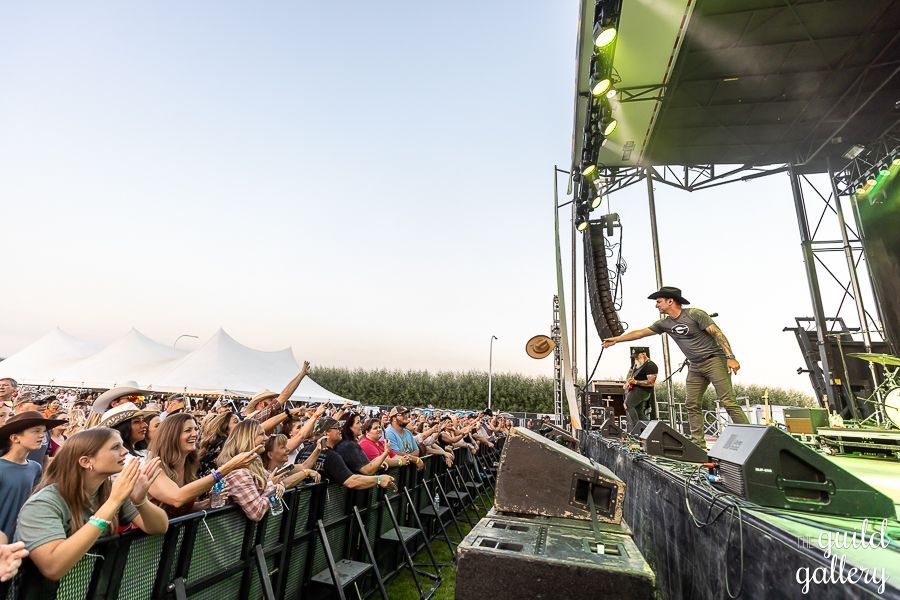 A man is standing on a stage in front of a crowd at a concert.