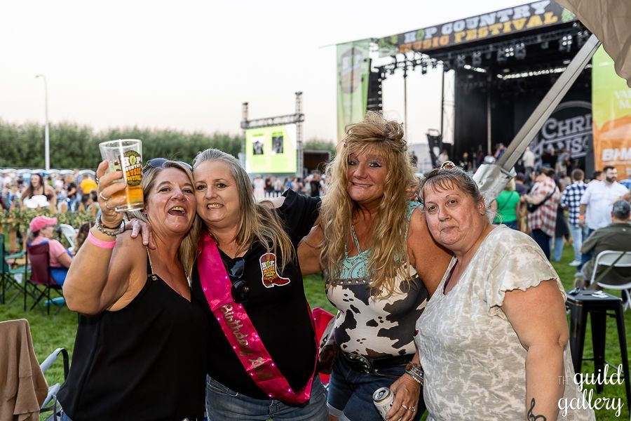 A group of women are posing for a picture at a concert.