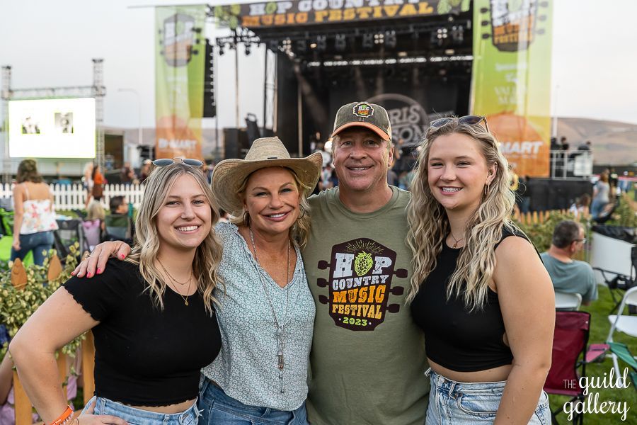 A family is posing for a picture at a music festival.