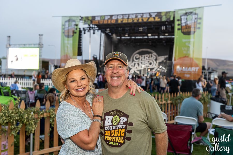 A man and a woman are posing for a picture at a music festival.