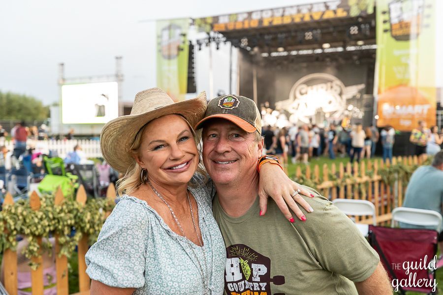 A man and a woman are posing for a picture at a concert.