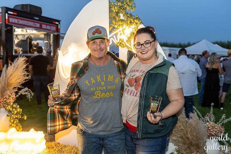 A man and a woman are posing for a picture at a festival.