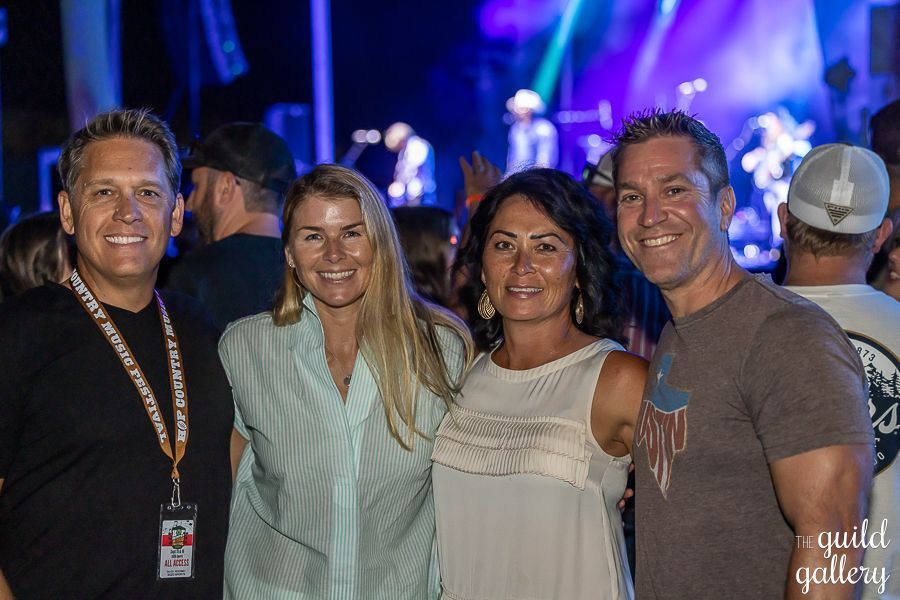 A group of people are posing for a picture at a concert.