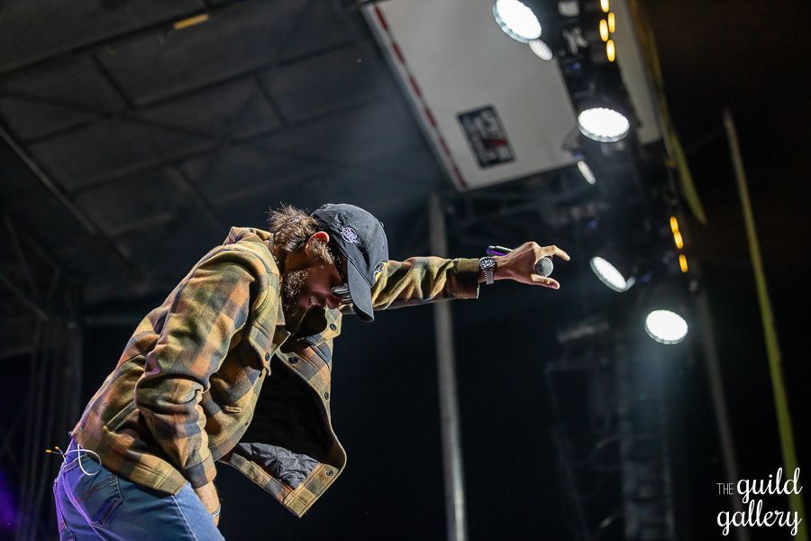 A man is standing on a stage with his arms outstretched.