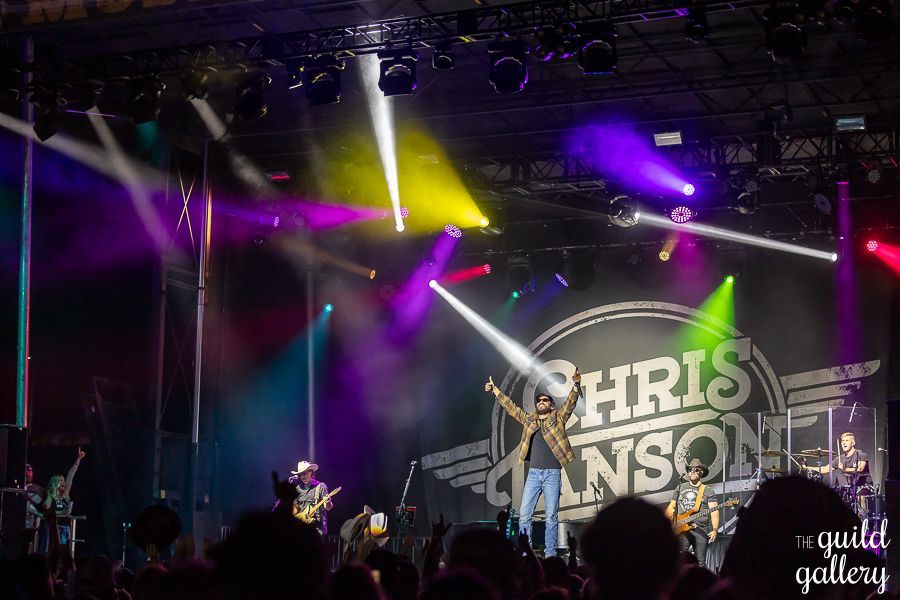 A group of people are playing instruments on a stage in front of a crowd.