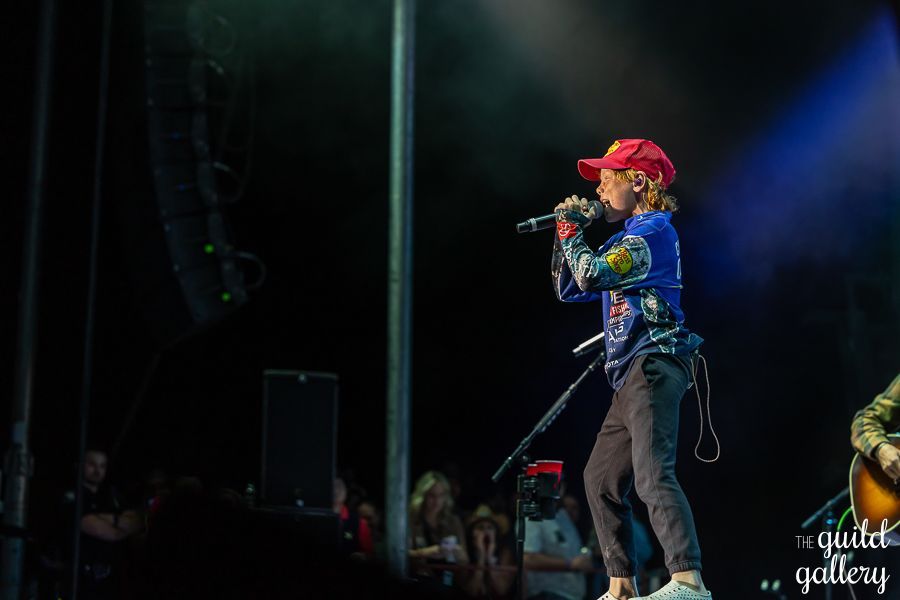 A person is singing into a microphone on a stage.