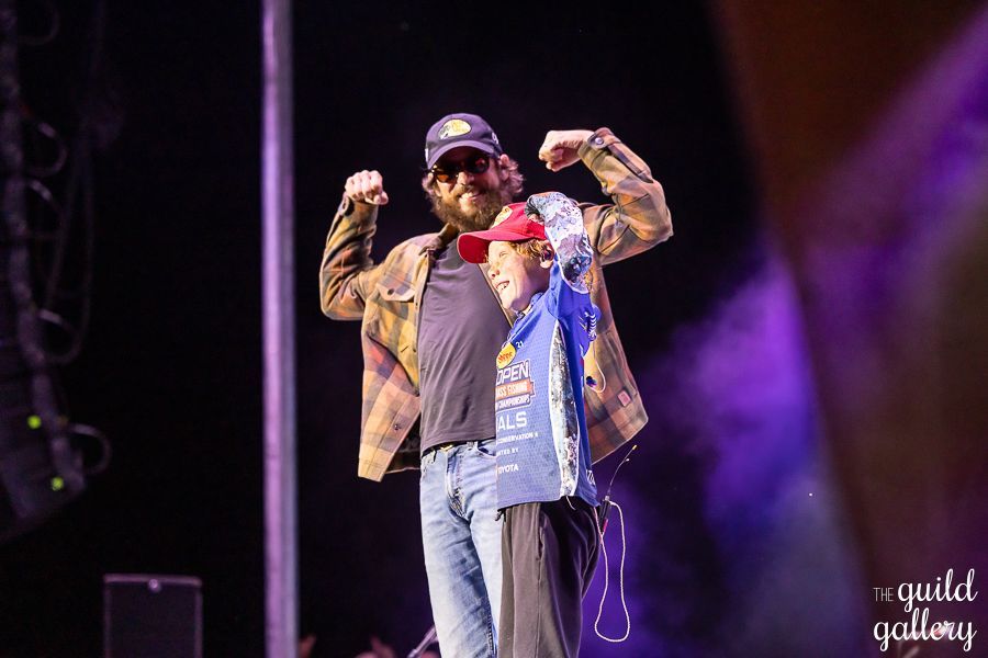 A man and a child are standing on a stage.