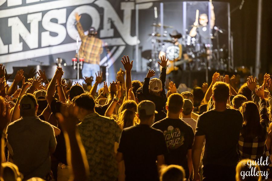 A crowd of people standing in front of a stage with the word nson on it