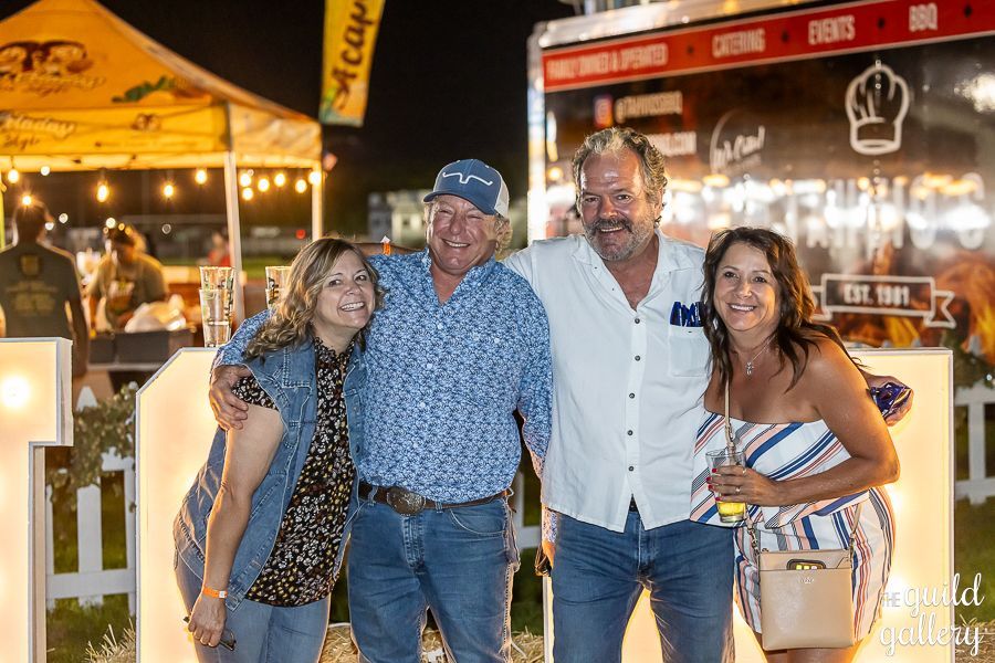 A group of people are posing for a picture in front of a food truck.