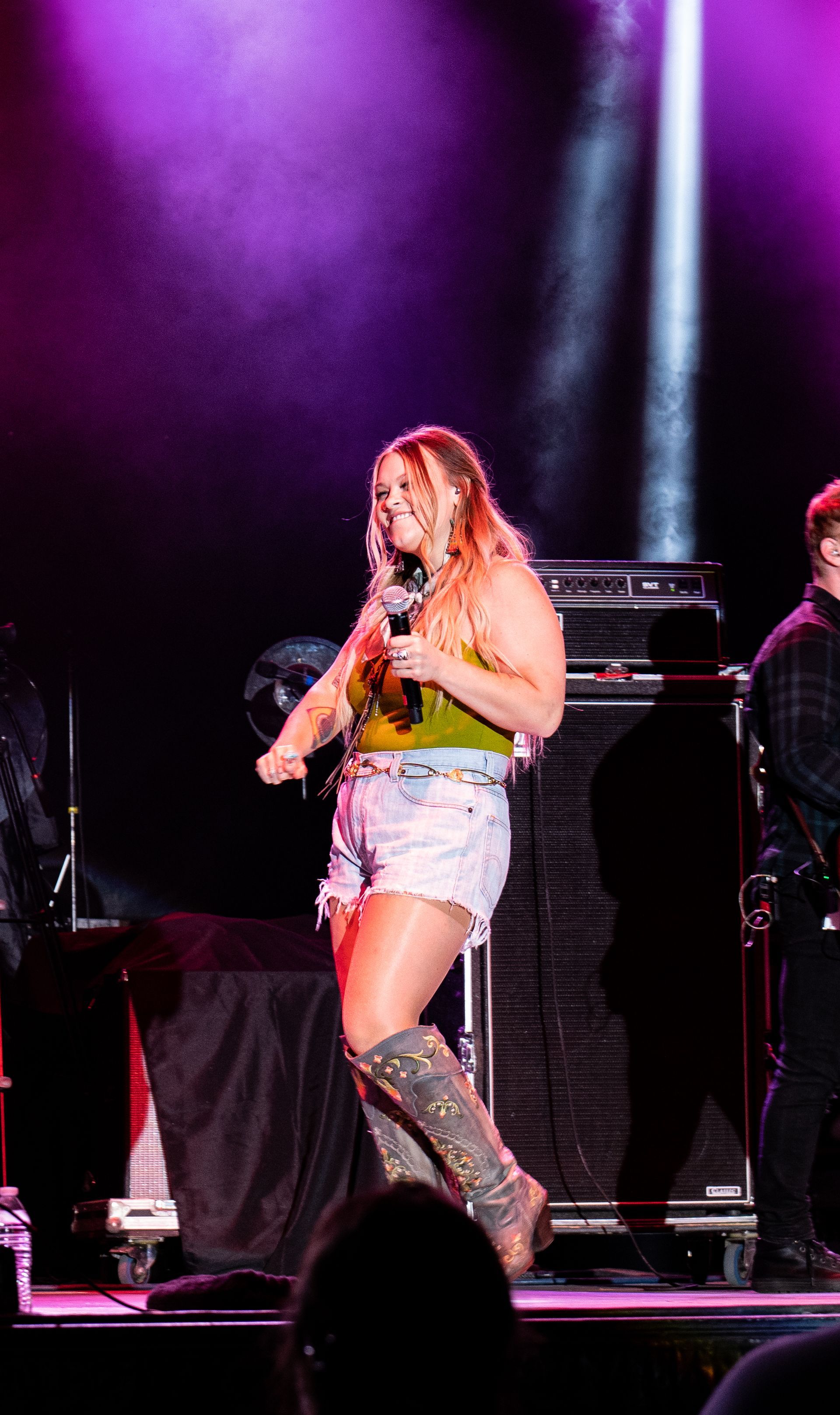 A woman is standing on a stage holding a microphone.