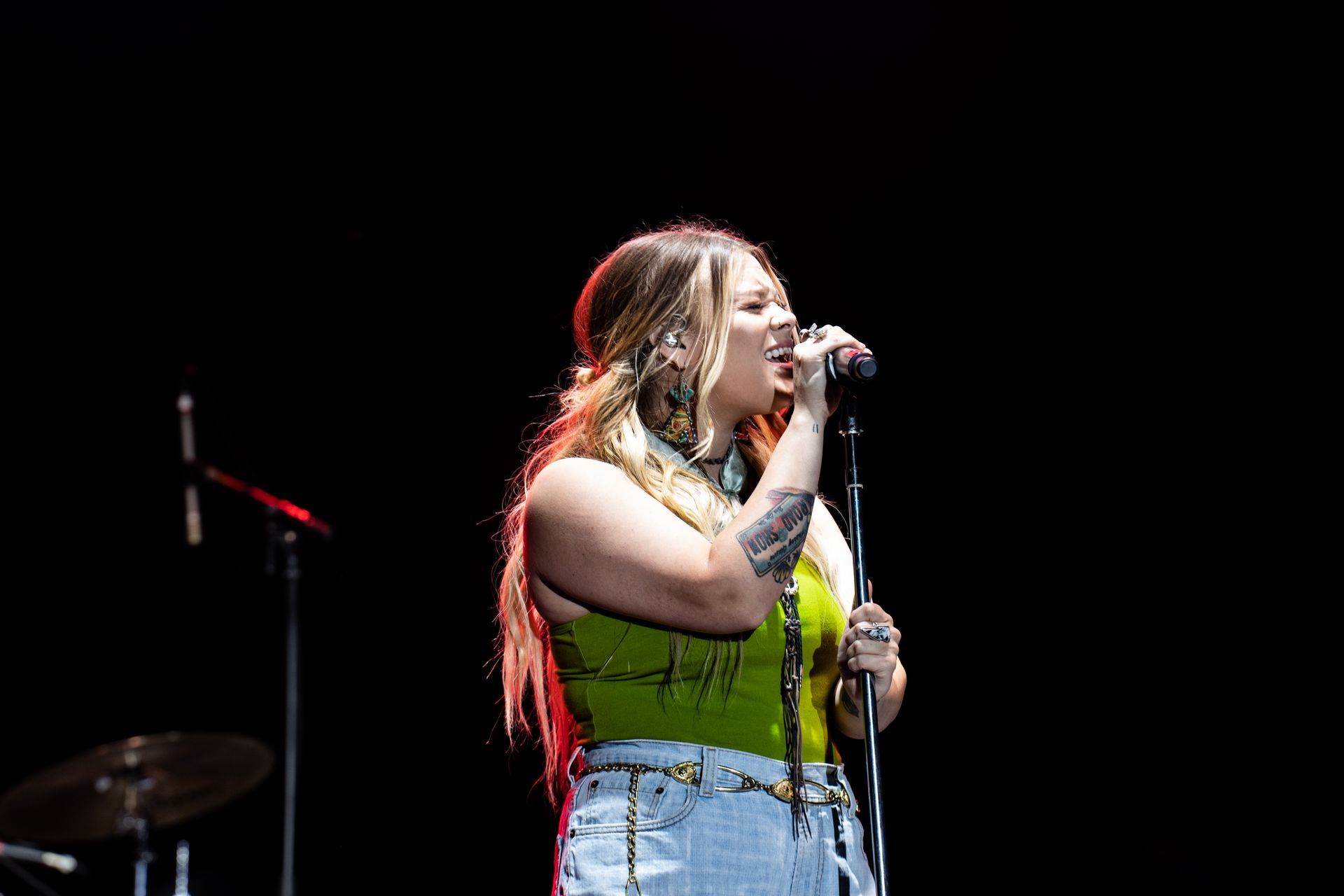 A woman is singing into a microphone on a stage.