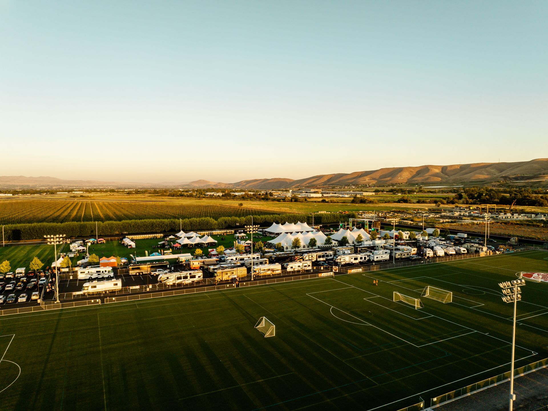 An aerial view of a soccer field with mountains in the background