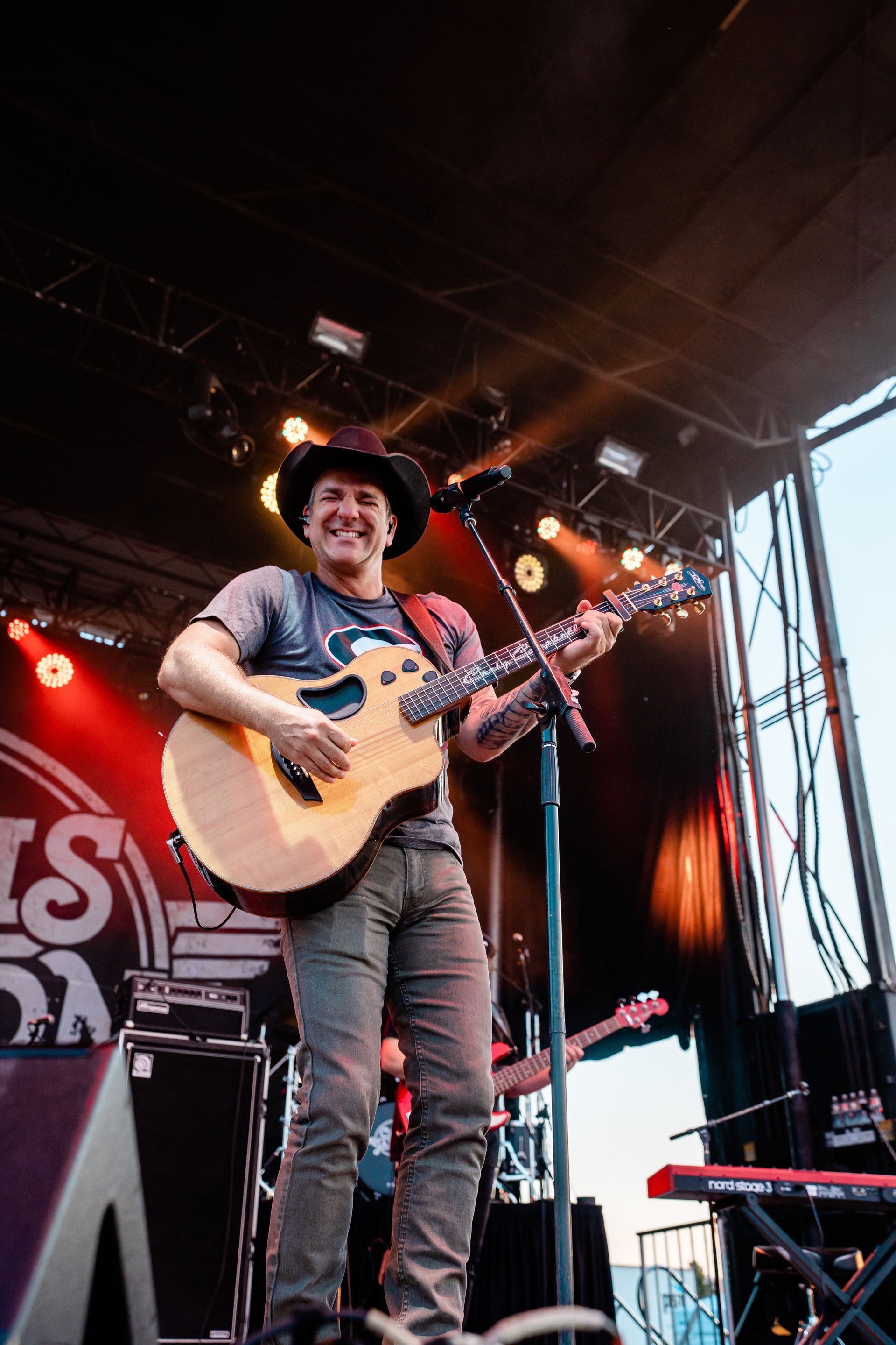 A man in a cowboy hat is playing a guitar on a stage.