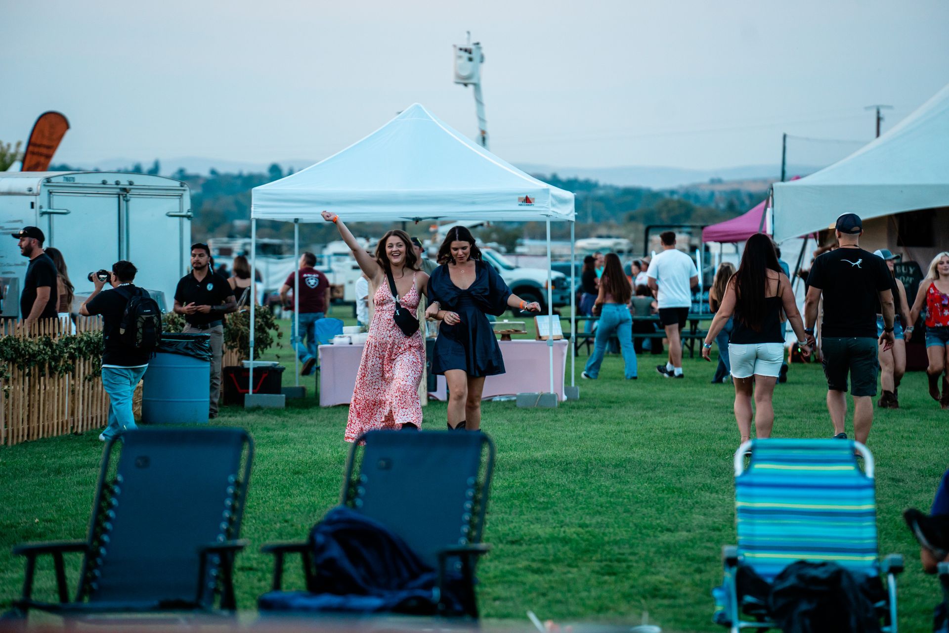 A group of people are walking through a field at a festival.