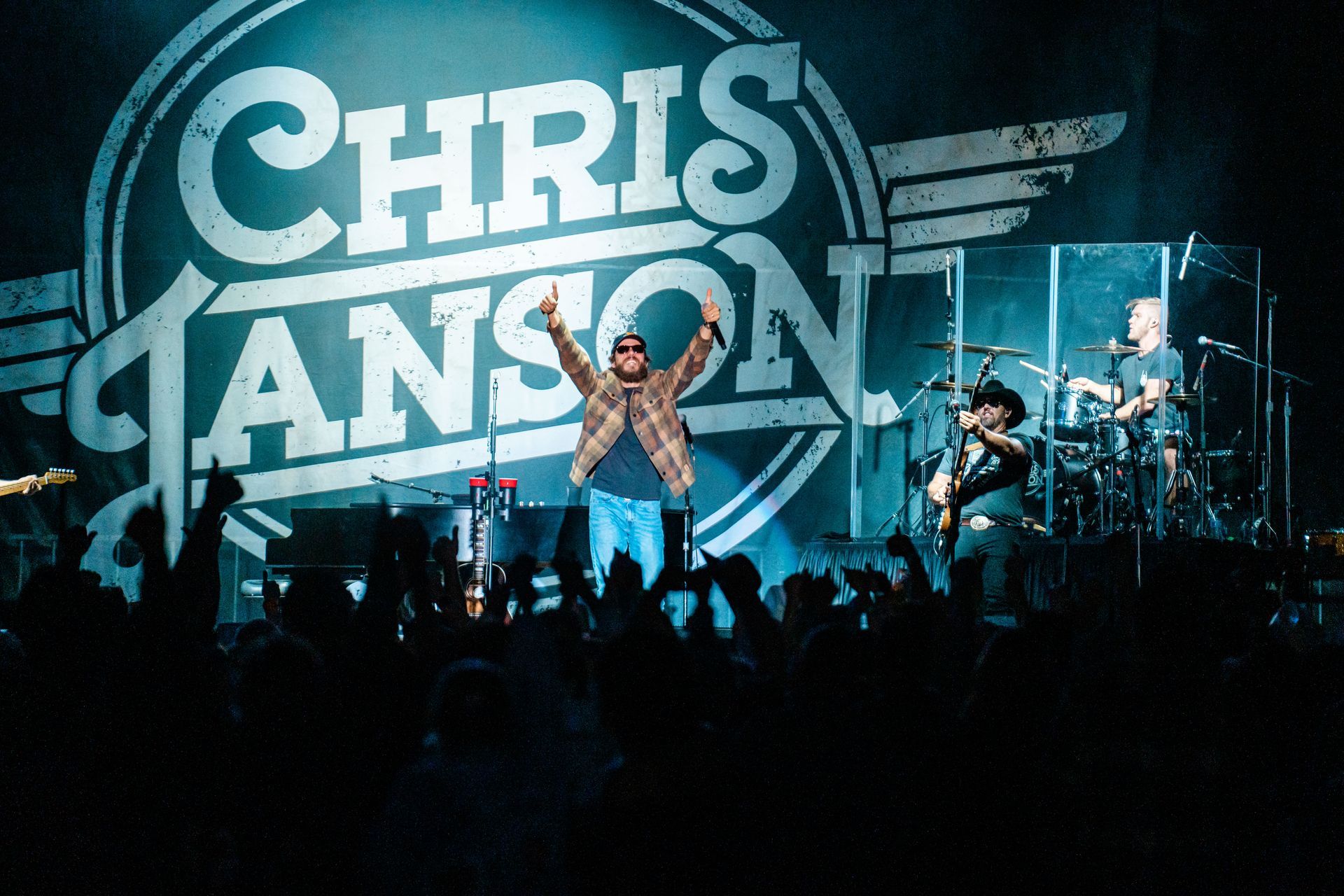 Chris janson is performing on stage in front of a crowd
