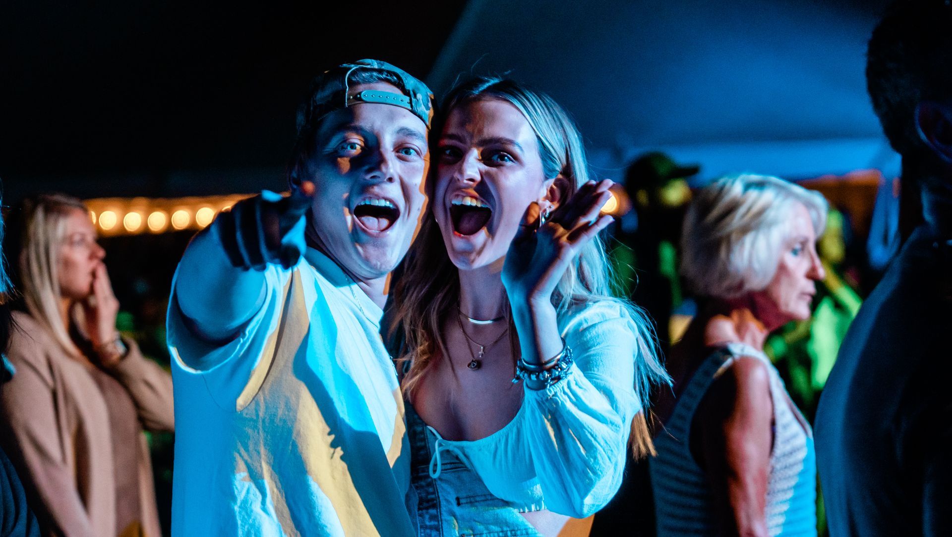 A man and a woman are standing next to each other at a party.