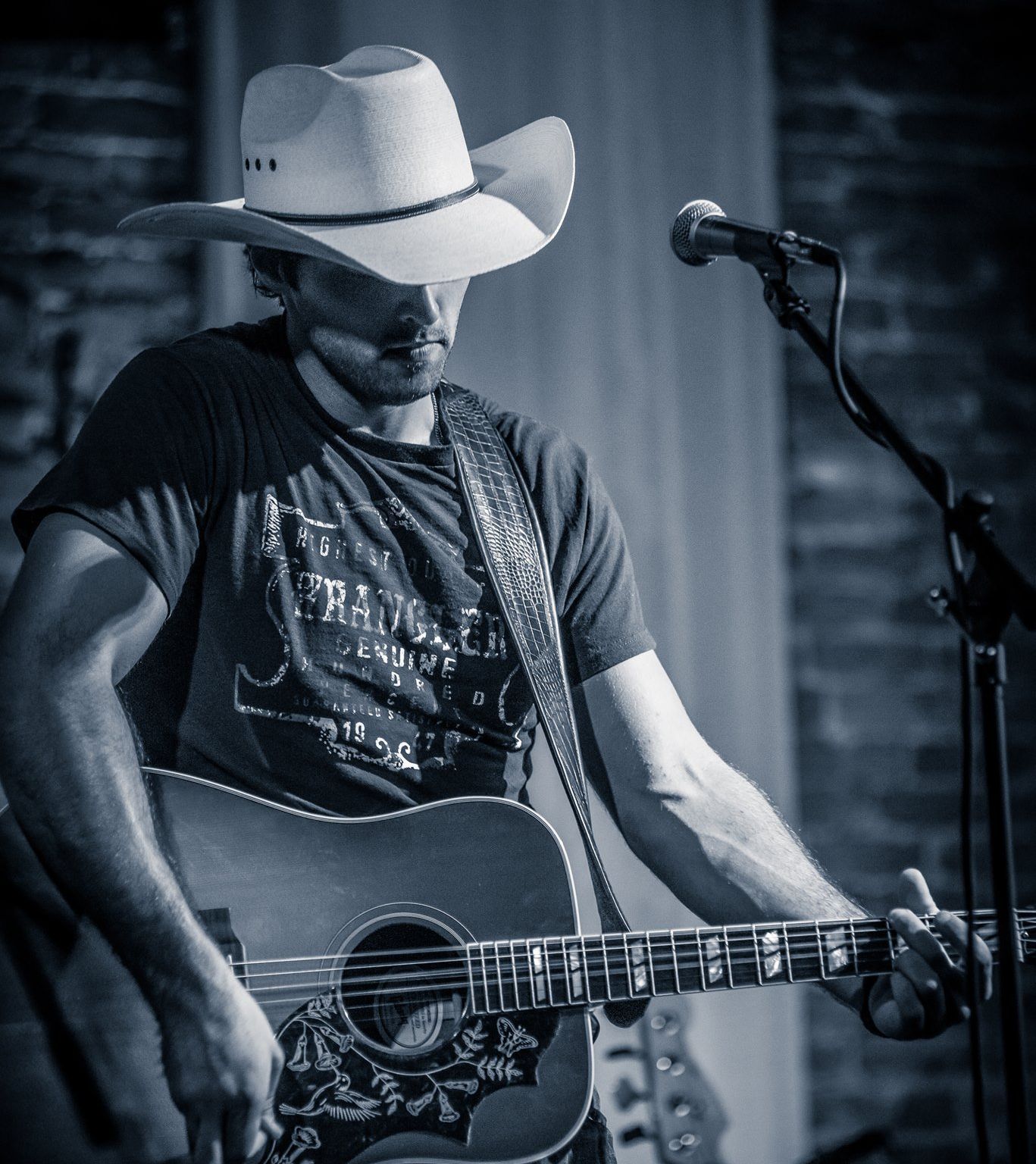 A man in a cowboy hat is holding a guitar