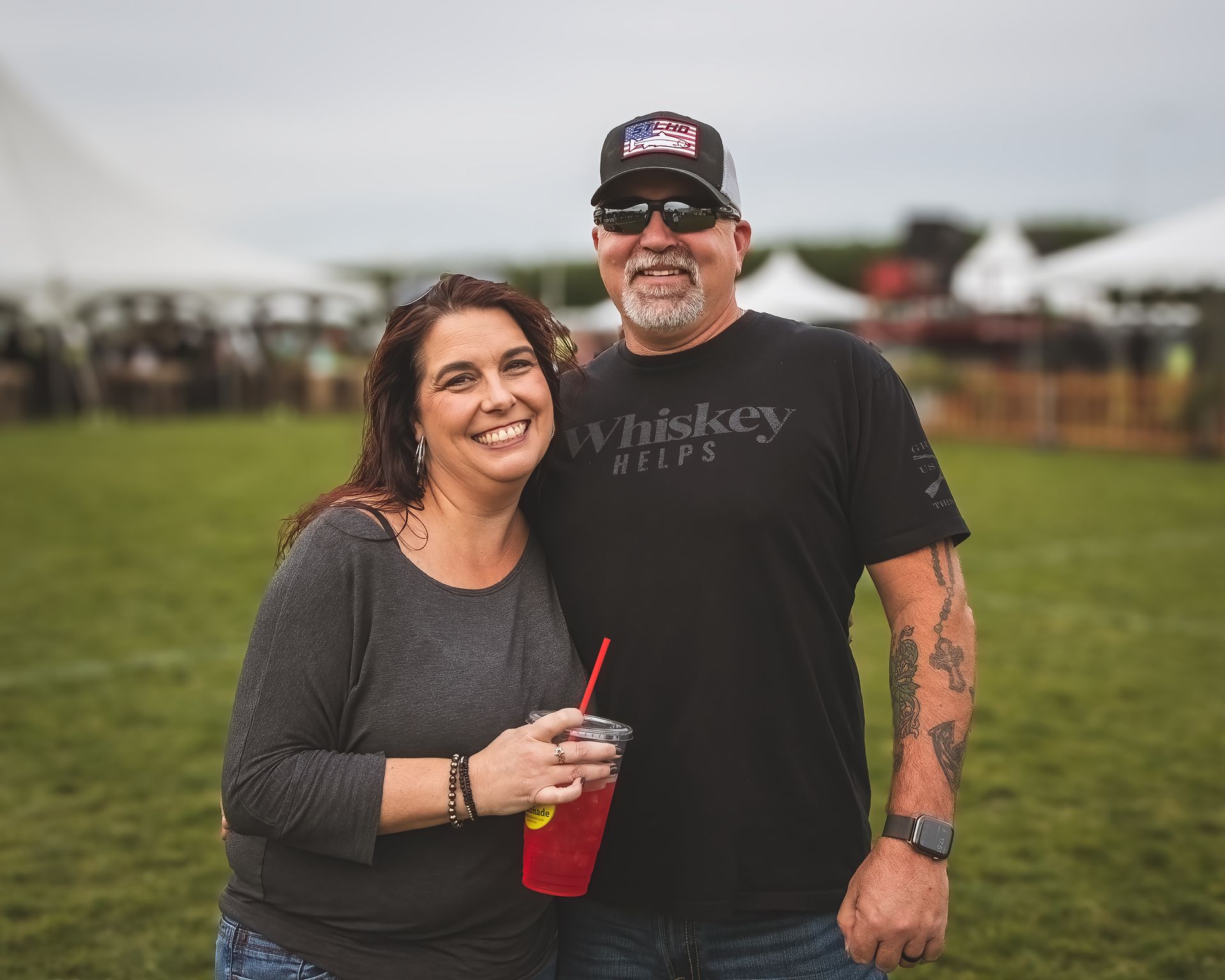 A man and a woman are posing for a picture in a field.