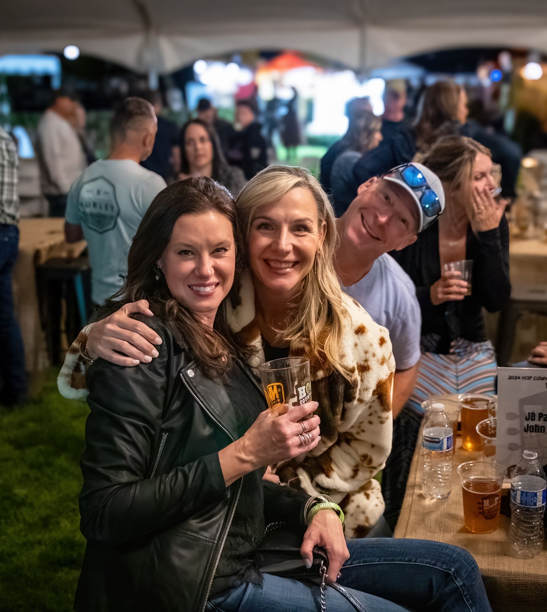 A group of people are posing for a picture while sitting at a table.