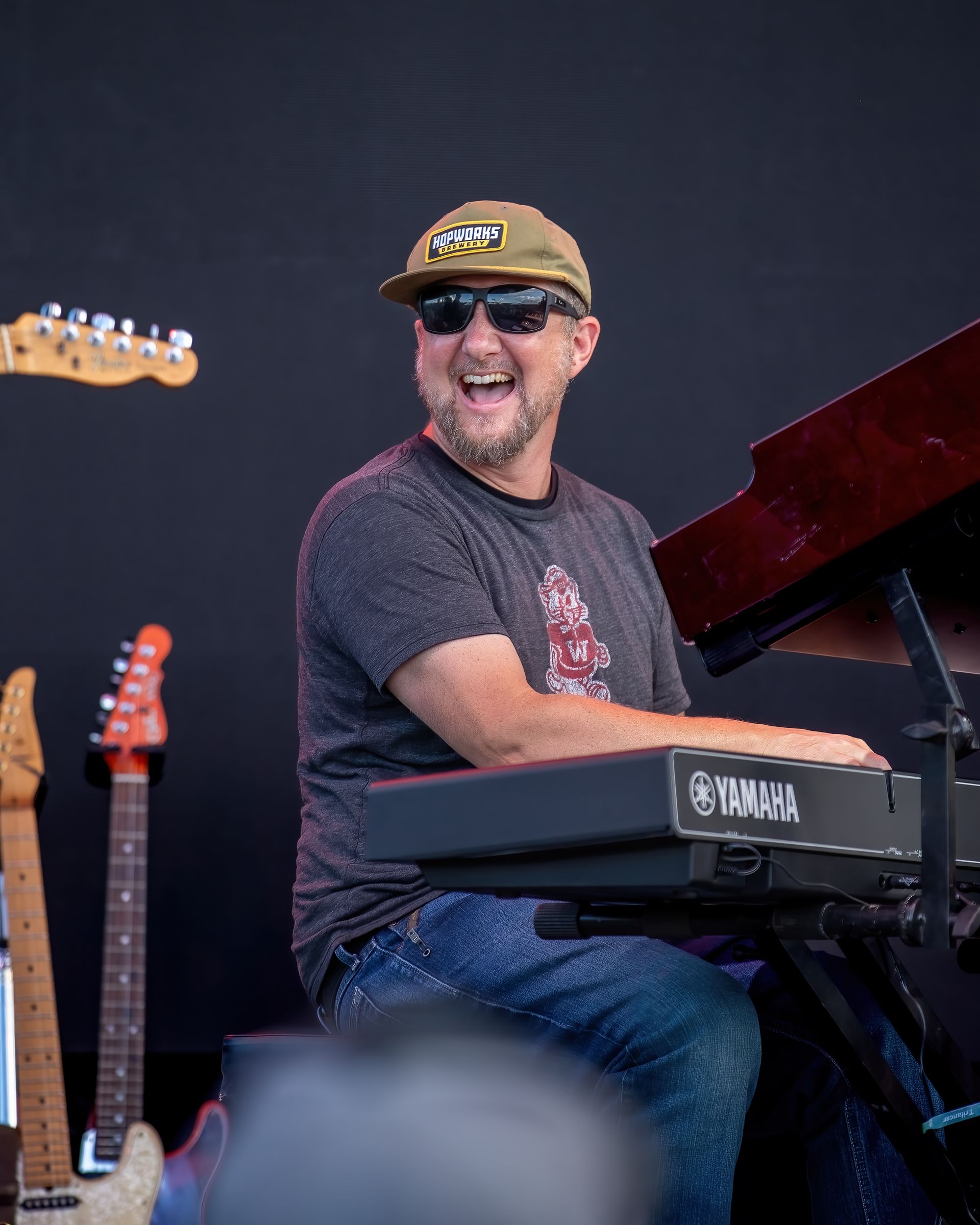 A man is playing a keyboard with a yamaha logo on it.