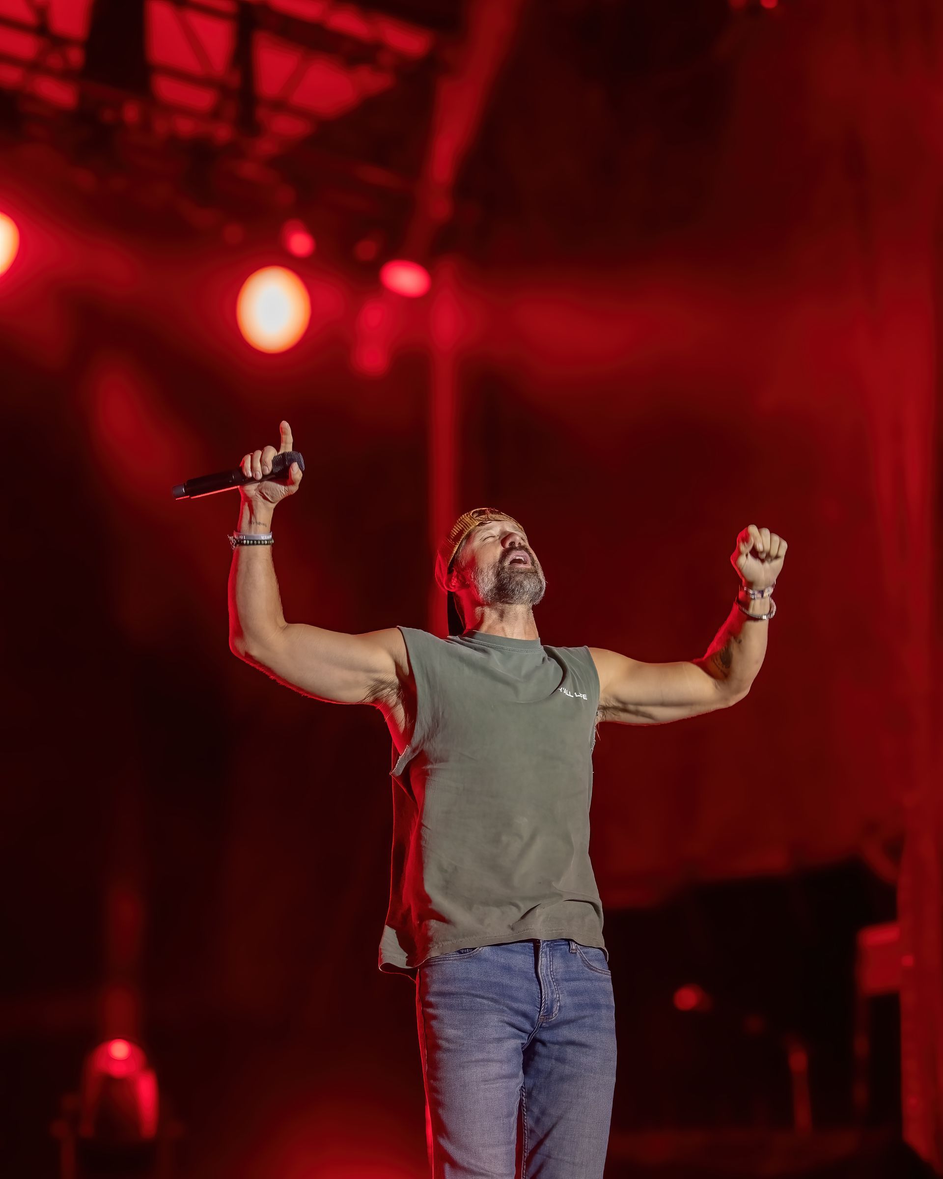 A man is singing into a microphone on a stage.