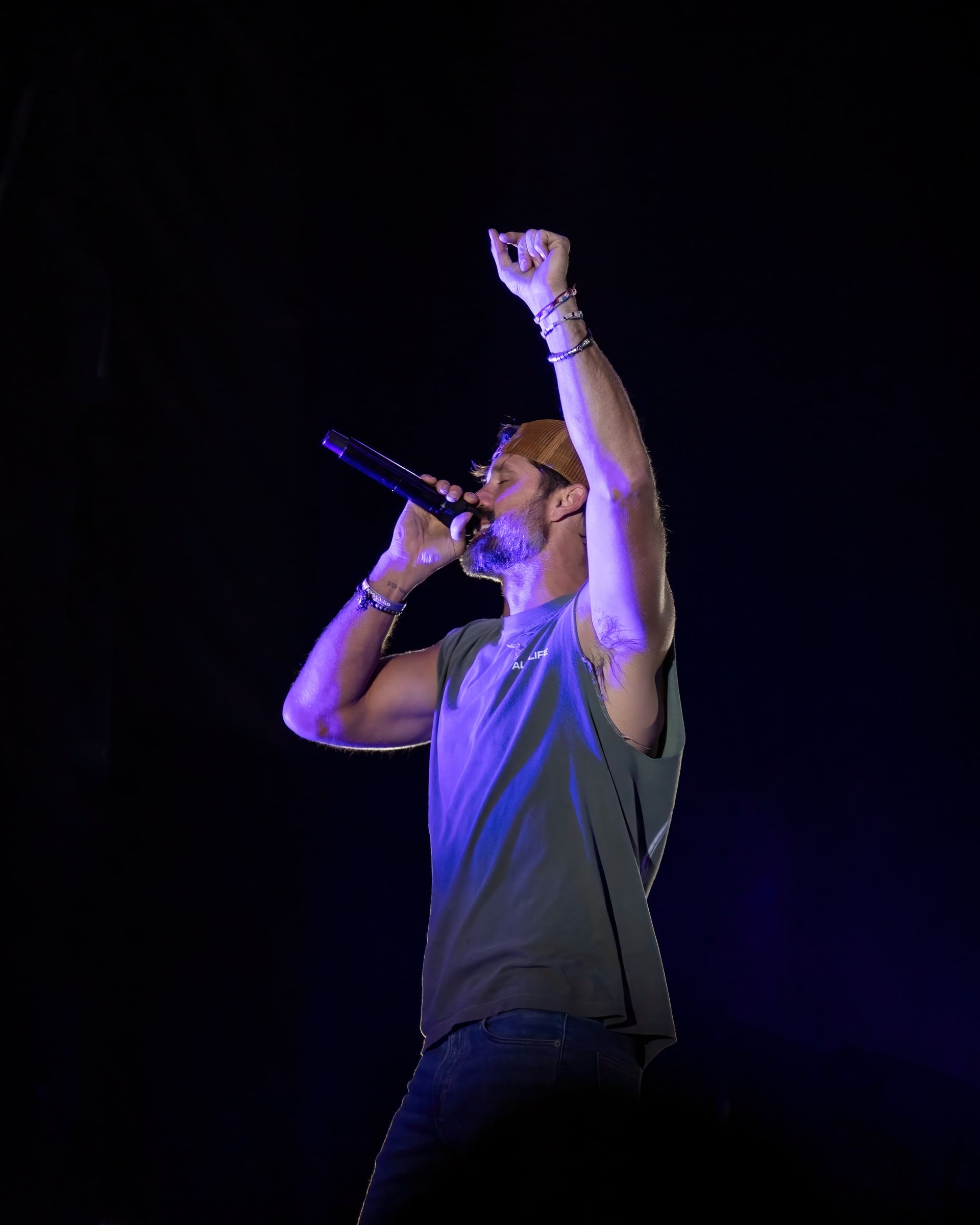 A man is singing into a microphone on a stage.