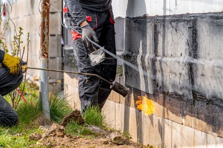 applying waterproofing solution to foundations