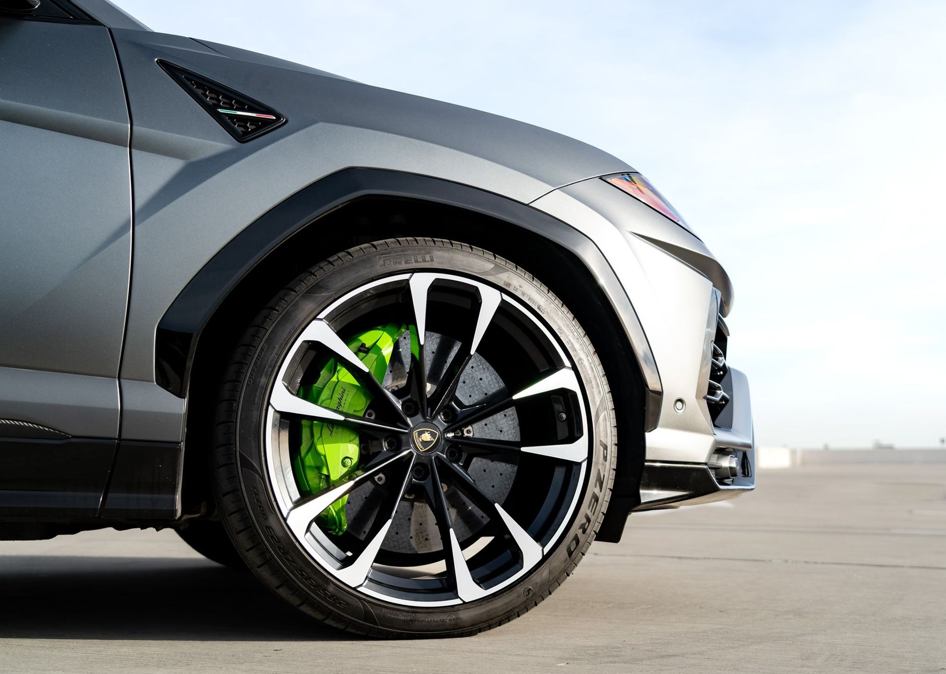 Close-up of a gray Lamborghini Urus wheel with lime green brake calipers.