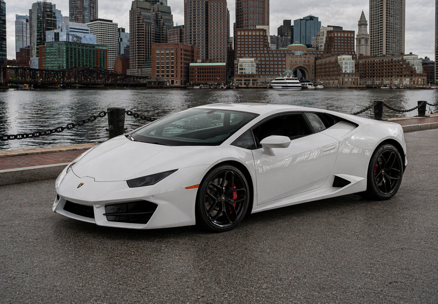 White Lamborghini sports car parked in front of a building with glass windows.