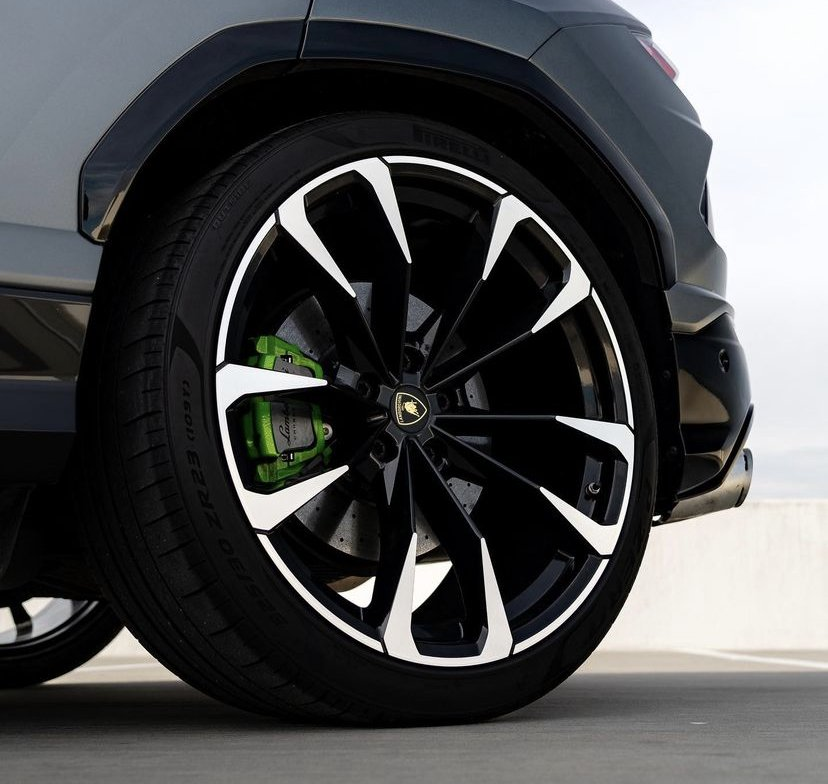 Black and white Lamborghini Urus wheel with green brake caliper.