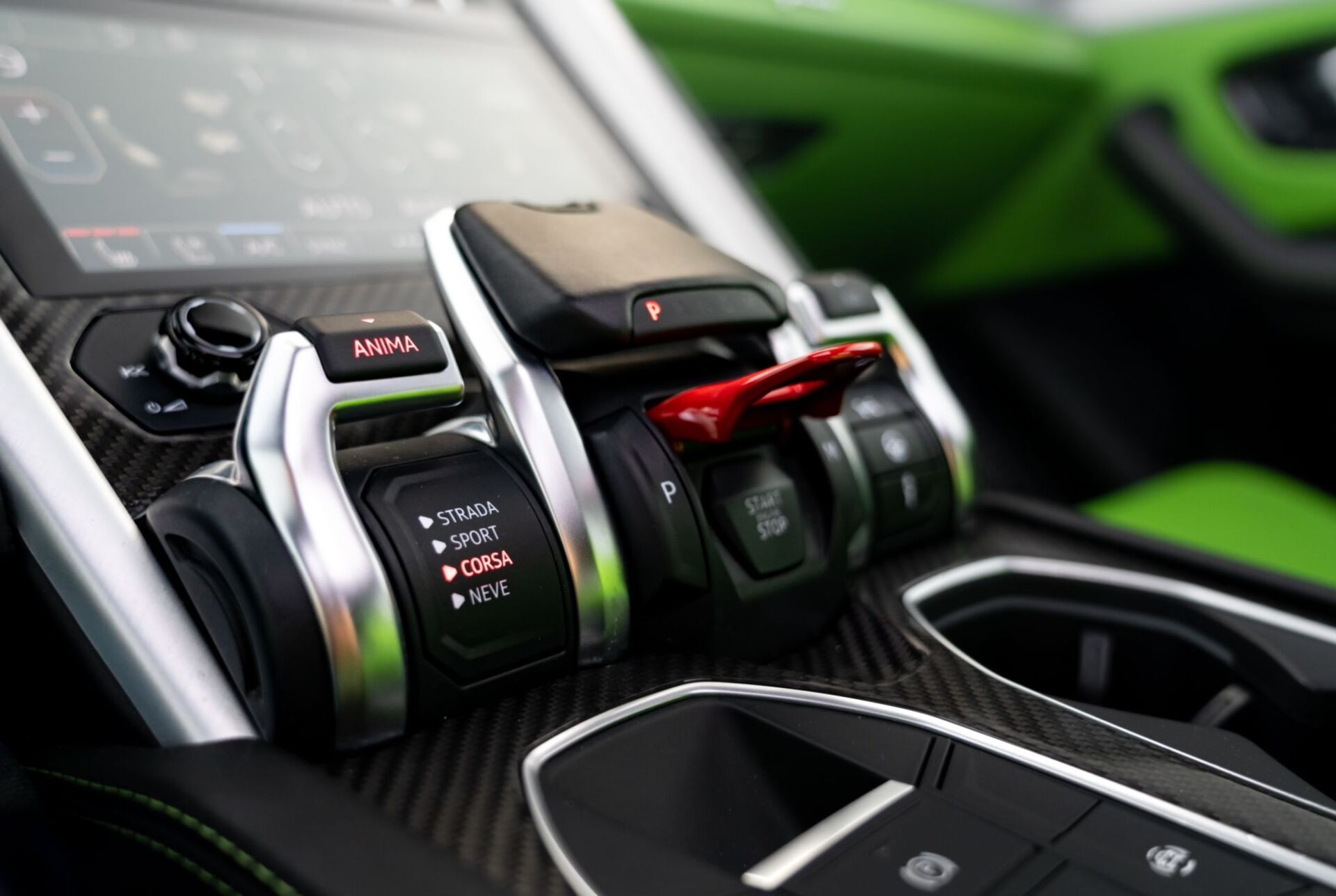 Close-up of a car's center console with gearshift, mode controls, and cup holders in a sporty design.