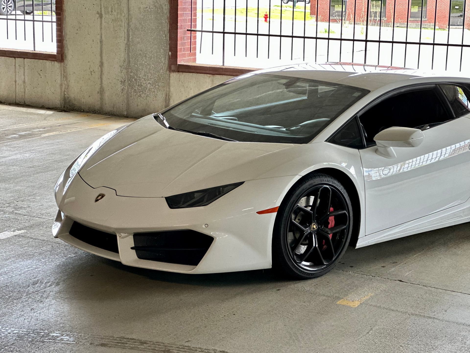 White Lamborghini sports car parked in a parking garage.