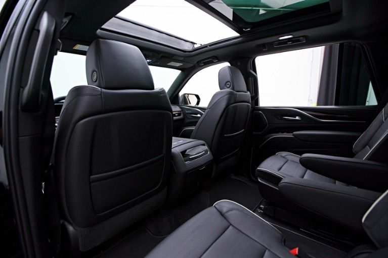 Black leather interior of a vehicle with a panoramic sunroof and bucket seats.