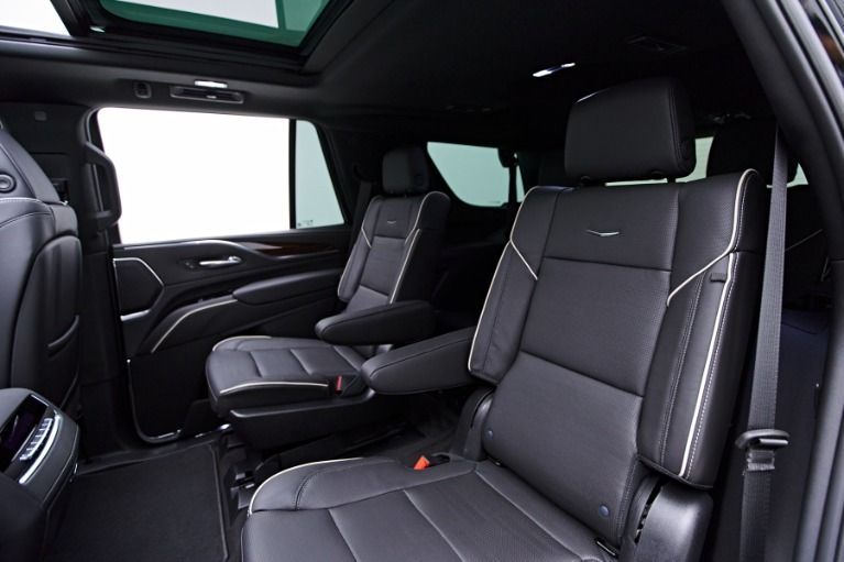 Black leather interior of a luxury SUV, with captain's chairs and a sunroof.