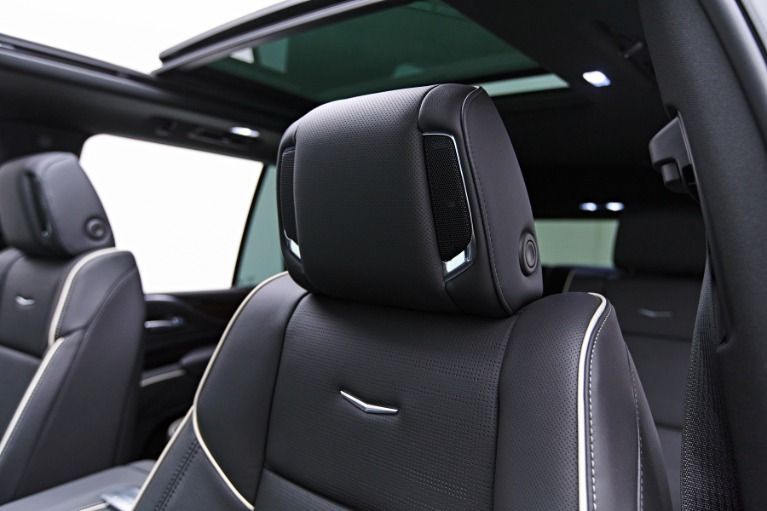 Black leather car seats with white stitching, chrome accents, and a panoramic sunroof.