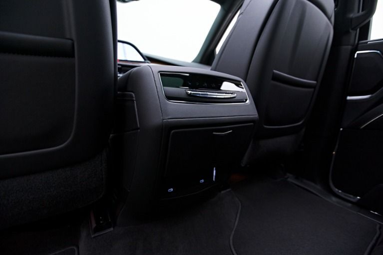 Black leather car seats with a center console featuring storage compartments.