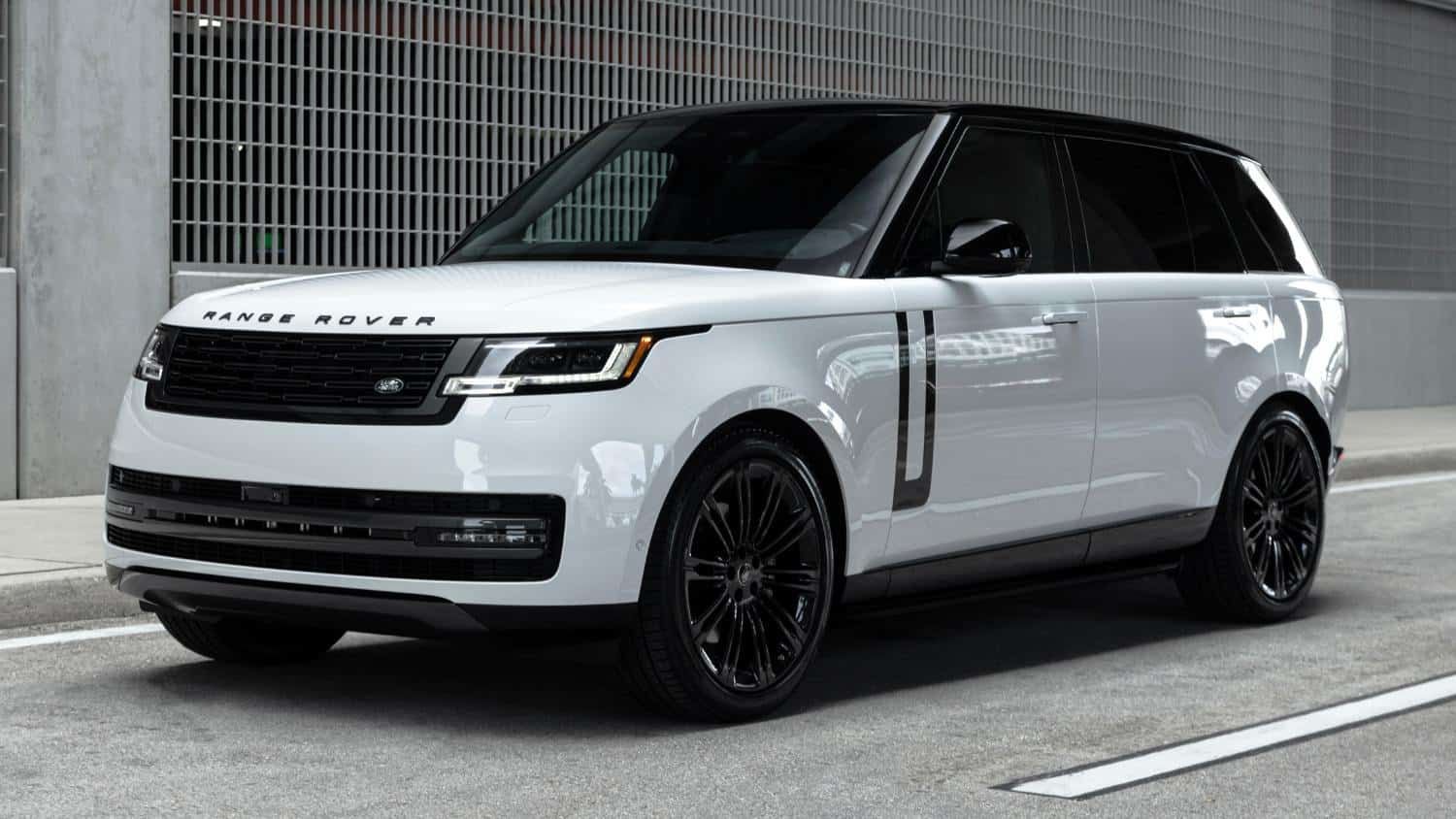 White Range Rover SUV with black accents parked on a city street.