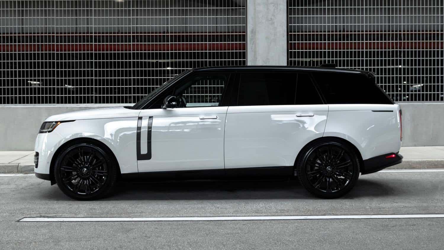 White Range Rover SUV with black roof and wheels parked on the street.