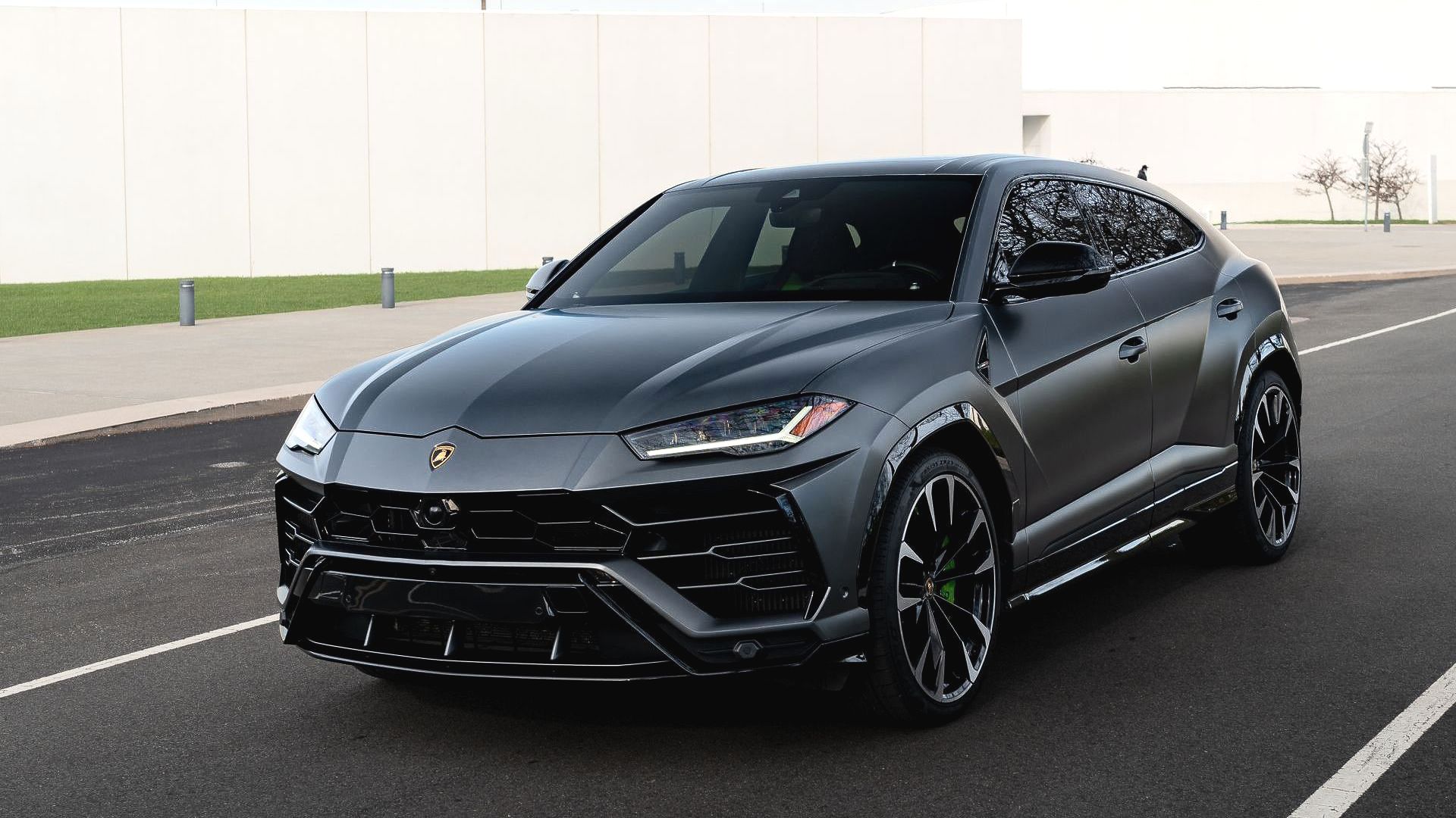 Dark gray Lamborghini Urus SUV on a road with black accents.