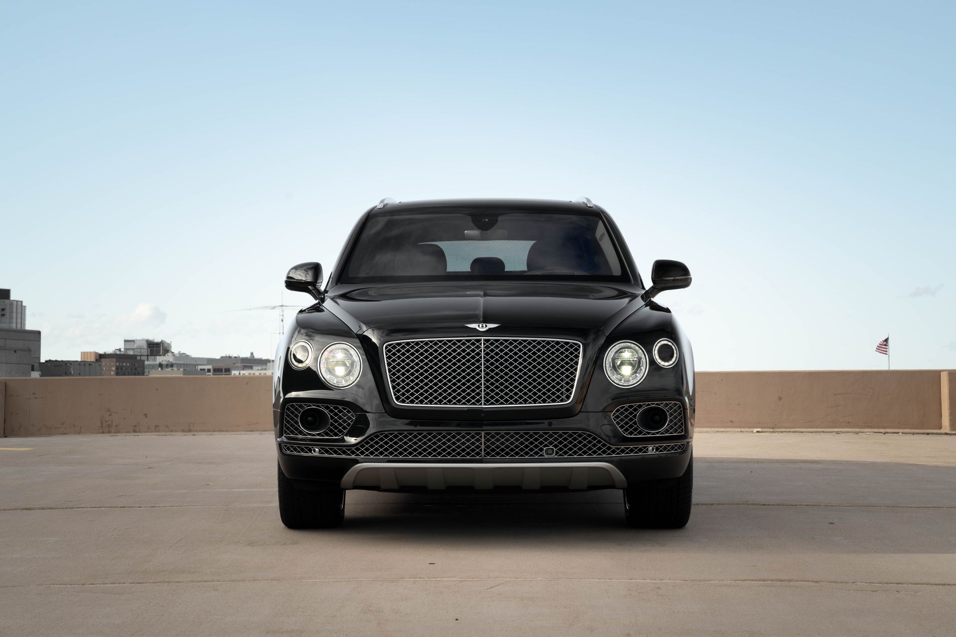 Black Bentley SUV parked on a rooftop, facing the camera.