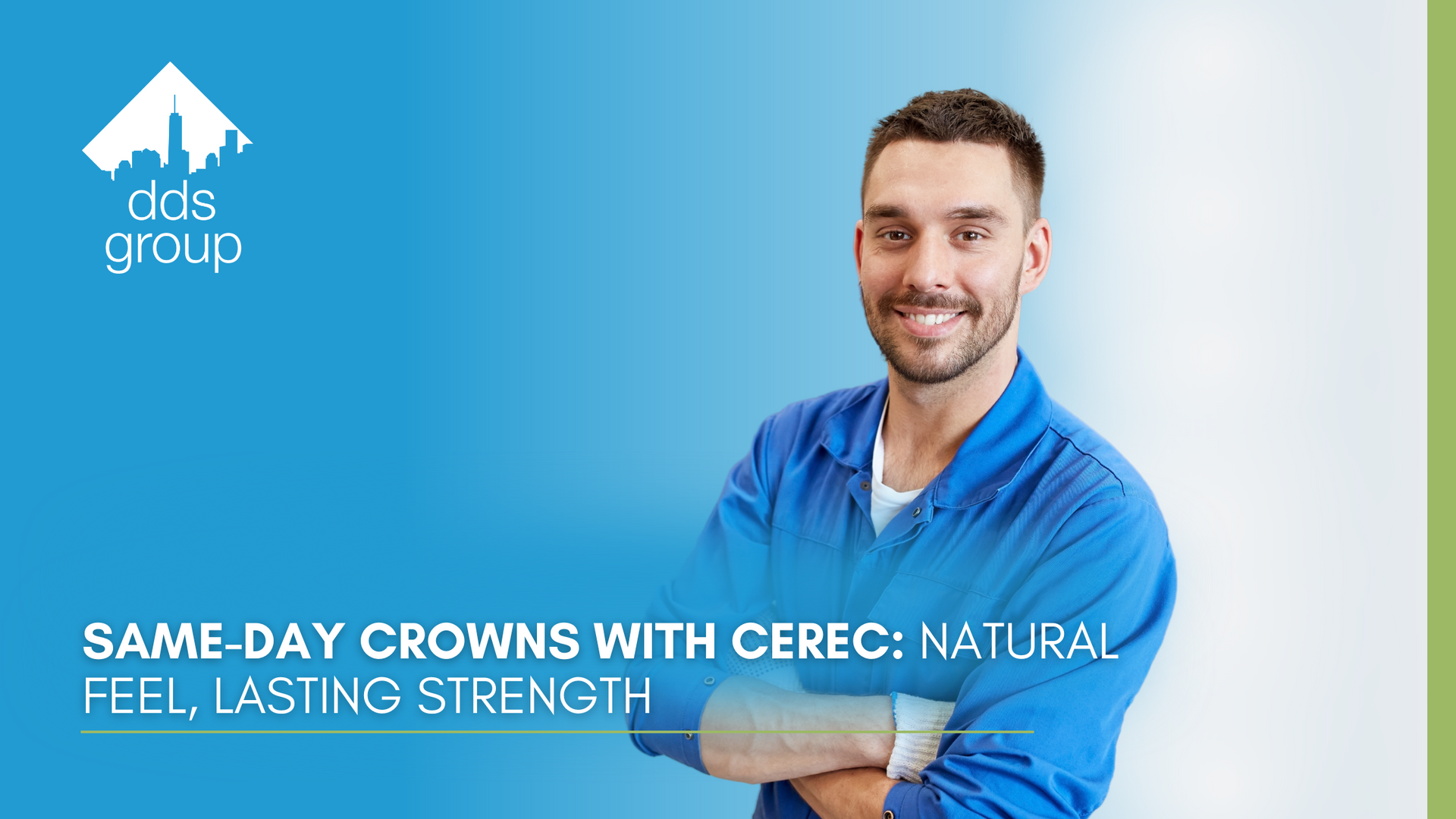 A man in a blue shirt is smiling with his arms crossed.