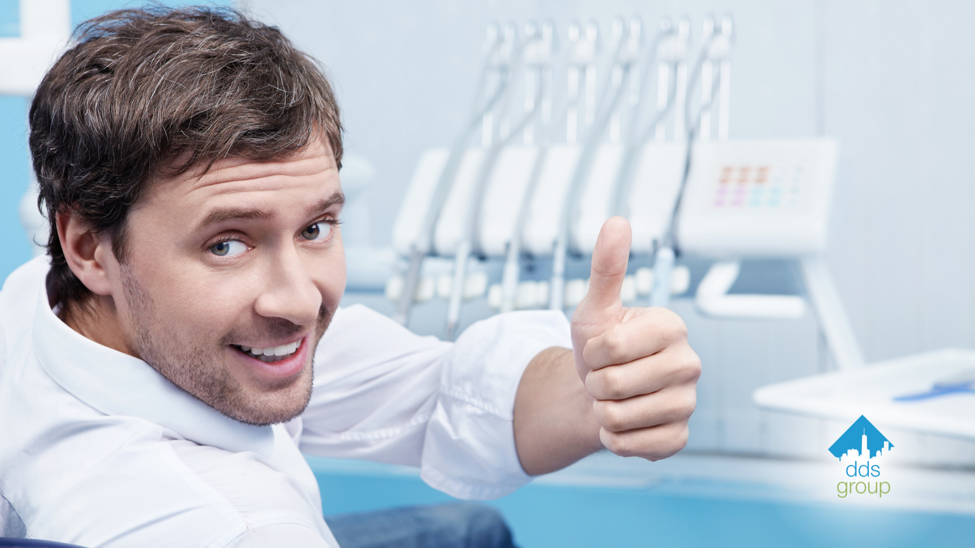 A man is giving a thumbs up in a dental office.