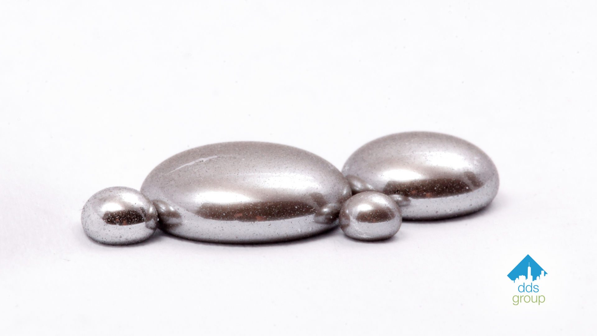 Three metal balls are sitting on a white surface.